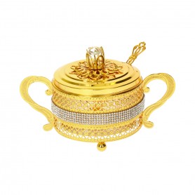 Glass sugar bowl with a diamond-shaped metal holder and a spoon