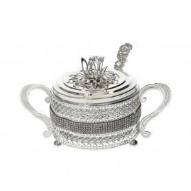 Glass sugar bowl with a diamond-shaped metal holder and a spoon